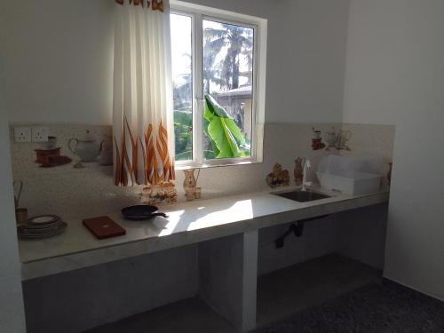a kitchen with a sink and a window at Ocean whisper residence in Ahangama