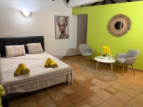 a bedroom with a bed and a table and chairs at Résidence la Baie de Ti t Anse in Pointe-Noire