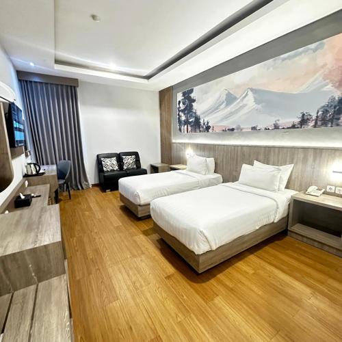 a hotel room with two beds and a couch at Azana Style Hotel Lovina Bali in Lovina