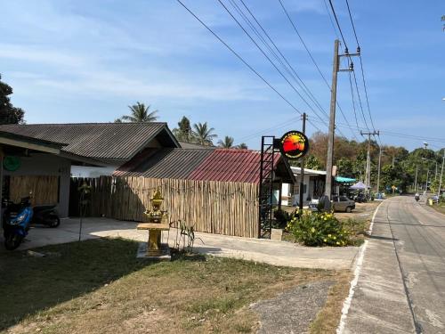 a building with a fire hydrant next to a street at Ban Supattra in Ban Khlong Mat