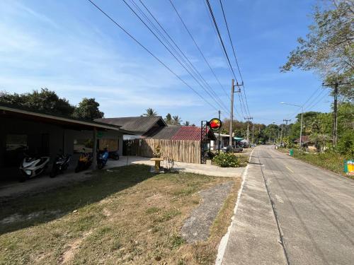 an empty street with a red traffic light next to a building at Ban Supattra in Ban Khlong Mat