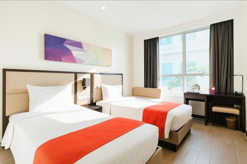 a hotel room with two beds and a desk at Hotel Lucky Chinatown Binondo Manila in Manila