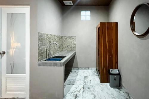 a bathroom with a sink and a mirror at Pondok Sagara Mitra RedDoorz in Kapal