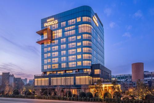 a tall building with a sign on top of it at Hotel Indigo Xi'an High-tech Zone by IHG in Xi'an