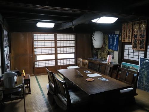 a dining room with a wooden table and chairs at OSHI-KIKUYA A Historic Mount Fuji Stay in Fujiyoshida