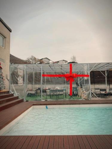a house with a pool with a red bow around it at Dohwa Pension Cheongju in Cheongju