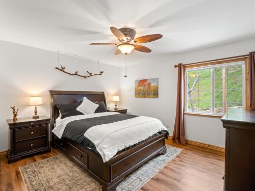 a bedroom with a bed and a ceiling fan at Manzanita Hill-35 miles to Yosemite, 10 miles to Mariposa with 8 person spa in Mariposa