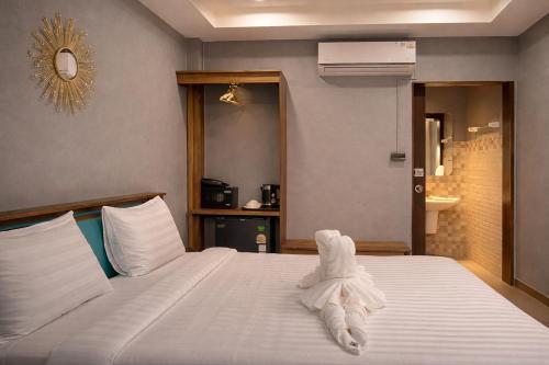 a hotel room with a bed with a towel on it at The Homey Boutique Rawai in Rawai Beach
