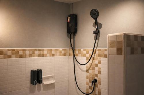 a shower in a bathroom with a blow dryer at The Homey Boutique Rawai in Rawai Beach