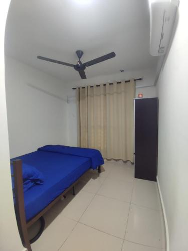 a bedroom with a blue bed and a ceiling fan at k homestay in Jeli