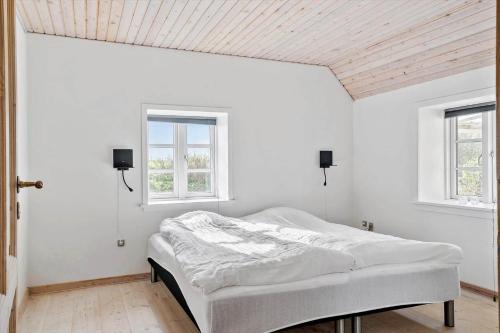 a white bedroom with a bed and two windows at 369-Lemvig-Klostervej-39 in Lemvig
