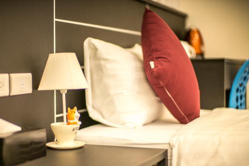 a bed with pillows and a lamp on a table at Full House in Jinning