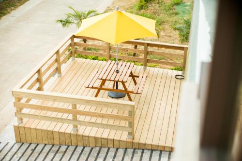 a wooden deck with a table and an umbrella at Full House in Jinning