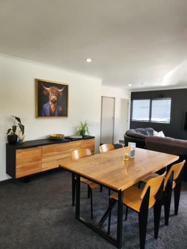 a living room with a wooden table and a couch at Mill Road Retreat Ohaupo in Kaipaki