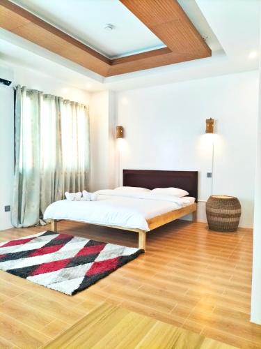 a bedroom with a bed and a rug at Alzurich Private Resort in Dauin