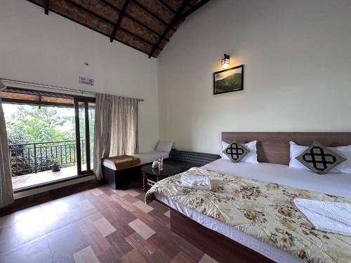 a bedroom with a large bed and a balcony at janani ecostay in Chikmagalūr