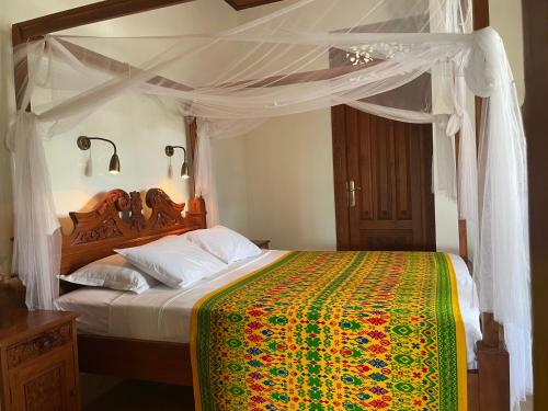 a bedroom with a large bed with a canopy at Gunung Paradis Retreat in Munduk