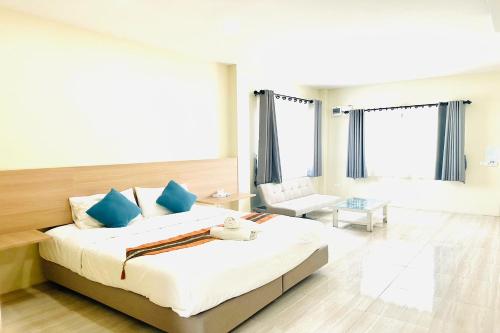 a bedroom with a large bed with blue pillows at Lampang Green Garden Resort in Ban Chomphu