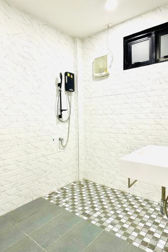 a bathroom with a sink and a phone on the wall at Lampang Green Garden Resort in Ban Chomphu
