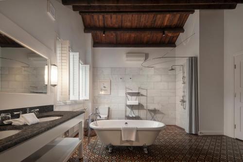 a bathroom with a large tub and two sinks at Mocun Resort in Deqing