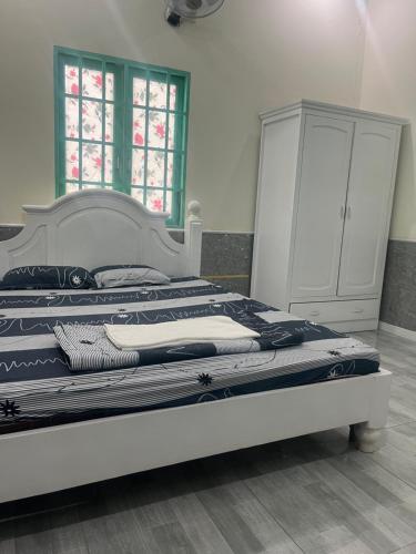 a bedroom with two beds and a dresser at Khách sạn Vườn Bưởi in Ấp Bình Sơn
