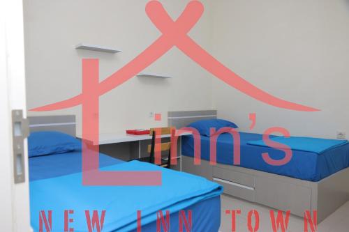 a room with two beds and a sign that says new homes at linns house borobudur syariah malang in Blimbing