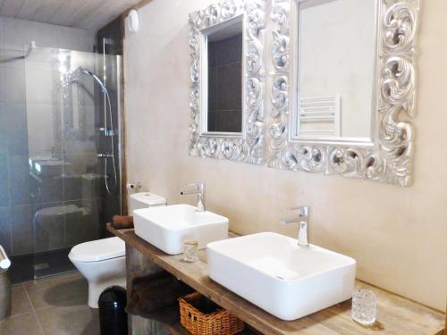 une salle de bain avec deux lavabos et un WC et un miroir dans l'établissement Les Chalets Aquarelle, à Chamonix-Mont-Blanc