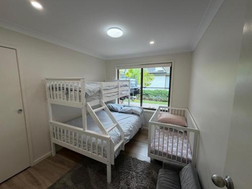 a bedroom with two bunk beds and a window at Mistral Breeze in Nelson Bay