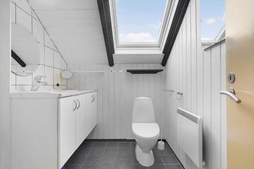 a bathroom with a toilet and a sink and a window at 2555-Romo-A-M-Listsvej-6 in Høm