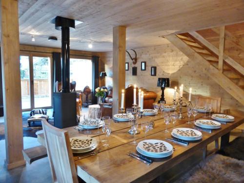 une table en bois avec des assiettes et des verres à vin dessus dans l'établissement Les Chalets Aquarelle, à Chamonix-Mont-Blanc