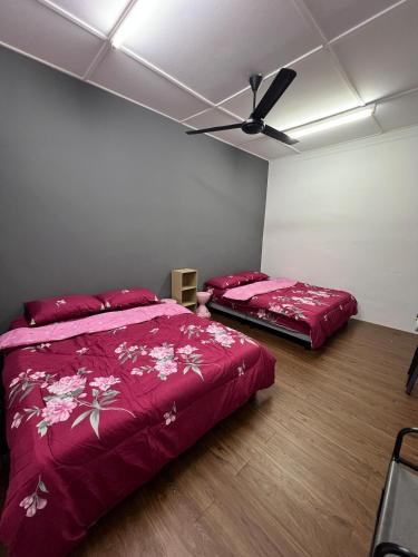 a bedroom with two beds and a ceiling fan at Classic Pearl Homestay in Teluk Intan