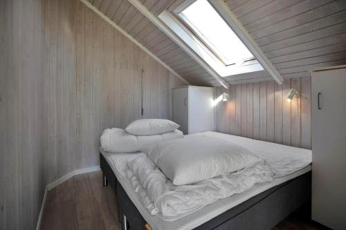 a large bed in a small room with a skylight at 14246-Grevinge-Egenaes-Vaenge-42 in Grevinge