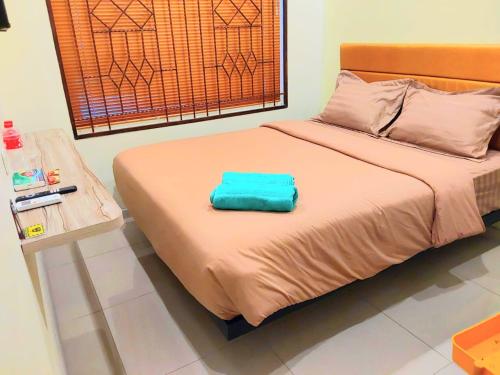 a bed with a blue pillow on top of it at Graha Citra Cirebon in Cirebon