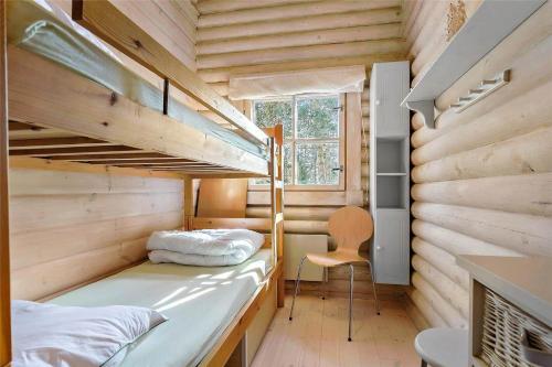 a room with two bunk beds and a chair at 10006-Rorvig-Hojsandsparken-3 in Rørvig