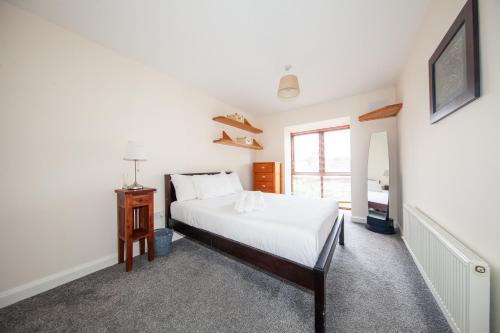 a bedroom with a white bed and a window at Spacious 2BDR Flat Near Portmarnock Beach in Dublin