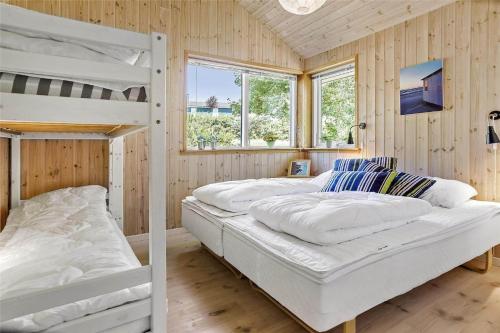 two bunk beds in a room with wooden walls at 16623-Farevejle-Stihojvej-14 in Fårevejle