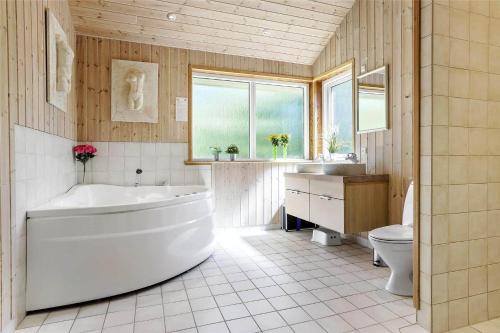a large bathroom with a tub and a toilet at 16623-Farevejle-Stihojvej-14 in Fårevejle