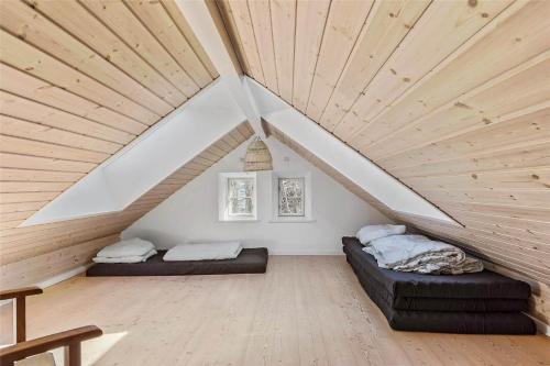 a attic room with two beds and a wooden ceiling at 16610-Farevejle-Mejsevaenget-26 in Fårevejle