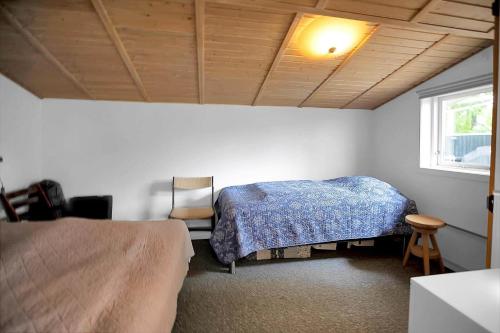 a bedroom with a bed and a chair and a window at 11136-Nykobing-Sj-Vindingsvej-2 in Nykøbing Sjælland