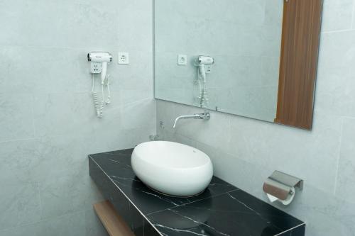 a bathroom with a sink on a counter with a phone at Azana Style Hotel Tulungagung in Tulungagung