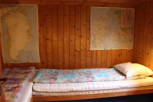 a bed in a wooden room with a map on the wall at 16626-Farevejle-Rormosen-56 in Fårevejle
