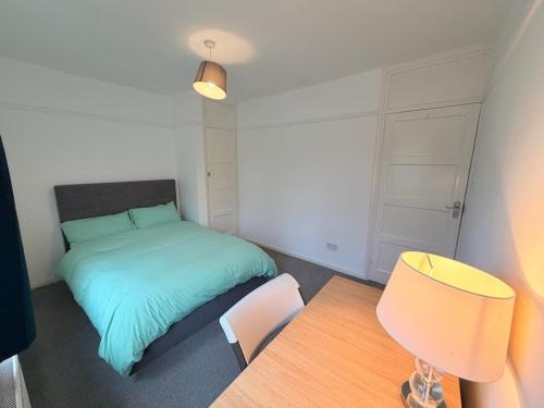 a bedroom with a bed and a table and a chair at Precious House 3 in Leicester