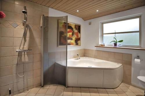 a bathroom with a tub and a shower and a sink at 16624-Farevejle-Stihojvej-25 in Fårevejle