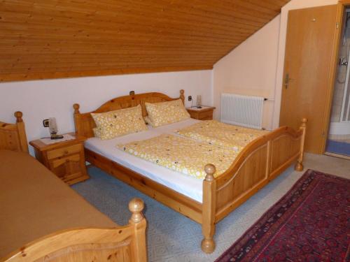 um quarto com uma cama de madeira e duas mesas de cabeceira em Gästehaus Zussner em Lochau