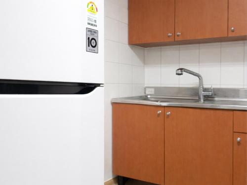 a kitchen with wooden cabinets and a sink at Seoraksan Youth Hostel in Sokcho