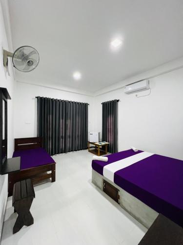 a bedroom with two beds and a desk in it at Flora Lake View Resort Wilpattu in Wilpattu