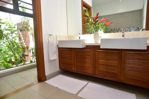 a bathroom with two sinks and a mirror at Coral Villa in Cap Malheureux