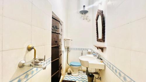 a bathroom with a toilet and a sink at Mosaics Guest House in Jaipur