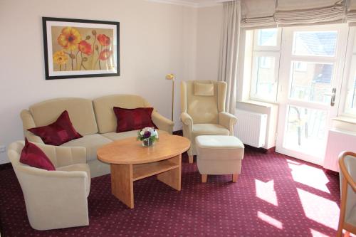 a living room with a couch and a table and chairs at Hotel Kirchspiels Gasthaus in Nortorf