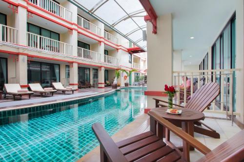 a swimming pool with chairs and a table next to a building at Kiang Haad Beach Hua Hin in Hua Hin